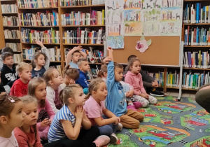 dzieci zgłaszają się do odpowiedzi siedząc przed leśnikiem