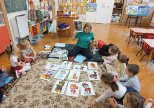instruktorka pokazuje dzieciom obrazki z psami z bajek