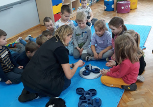 instruktorka wraz z dziećmi przygotowuje zabawę dla psów