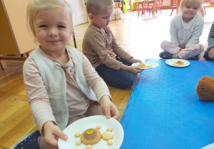 dzieci pokazują talerze z ułożonym z ciastek misiem