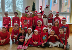 dzieci w czerwonych strojach z grupy VIII z Mikołajem