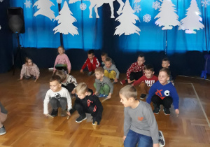 dzieci wystukują rytm uderzając drewienkami o podłogę