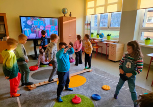 zabawy ruchowe z krążkami i na drewnianej kładce