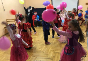 dzieci bawią się balonami podrzucając je do góry