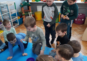 zabawa sprawnościowa - chłopiec nabiera łyżką przysmak dla psa z miski