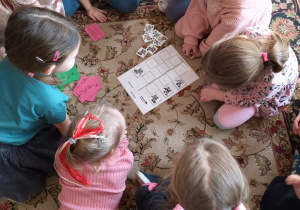 przedszkolaki szukają par psów i układają obrazki na kartce