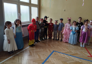 dzieci w kostiumach na balu karnawałowym w SP Nr 10 w Zduńskiej Woli stoją na obwodzie koła