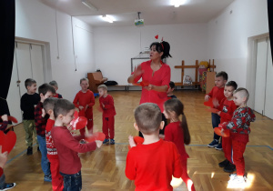 zabawy z Panią Nutką - dzieci uderzają dłonią w papierowe serce