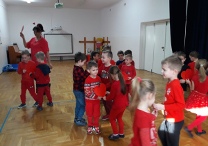 zabawy z Panią Nutką - dzieci tańczą w parach trzymając duże serce