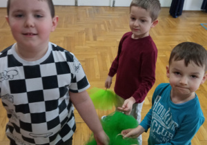 chłopcy stoją w grupie z zielonymi pomponami