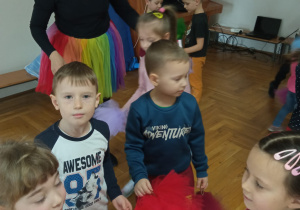dzieci stoją w grupie z czerwonymi pomponami