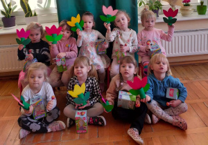 dziewczynki zdrobnymi upominkami i kwiatkami pozują do zdjęcia grupowego