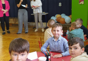 chłopcy siedzą przy stoliku podczas konkursu