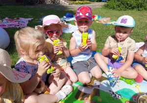 dzieci piknikują w ogrodzie przedszkolnym