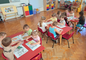 dzieci przy stolikach malują wodne malowanki
