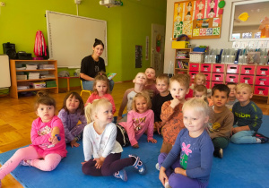 przedszkolaki siedzą na dywanie przed mamą