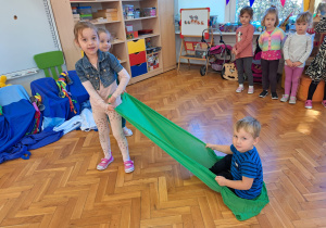 dziewczynki ciągną chłopca na chuście