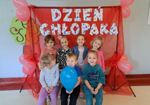 dzieci z gr VI pozują do zdjęcia w ramce z napisem Dzień Chłopaka