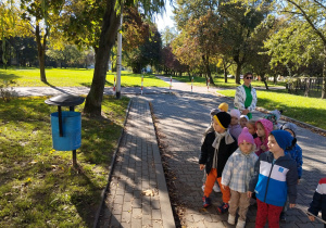 dzieci podczas spaceru oglądają kosze na odchody zwierząt