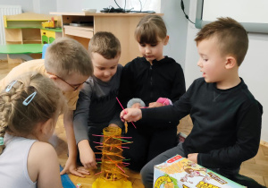 dzieci grają w grę zręcznościową z patyczkami