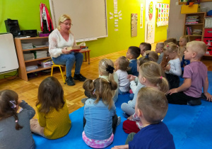 przedszkolaki słuchają bajeczki czytanej przez mamą koleżanki