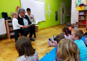 przedszkolaki słuchają bajeczki czytanej przez mamą koleżanki i kolegi