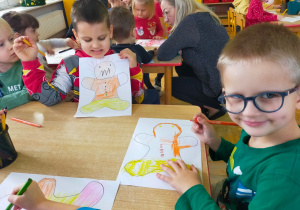 przedszkolaki rysują ludzikom miny wyrażające emocje