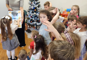 dziewczynka wskazuje włąsciwy obrazek trzymany przez panią psycholog