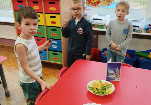 chłopcy częstują się ciastakami i owocami