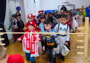 przedszkolaki pzrechodzą kolejno pod bramką