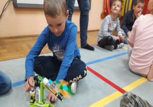 chłopiec bawi się robotem z klocków