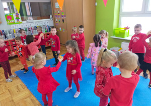 dzieci tańczą w parach z jabłkiem