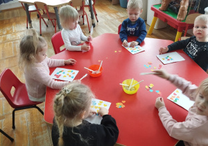 dzieci naklejają na walentynki kolorowe serduszka