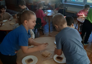 dzieci smarują nutellą wafle