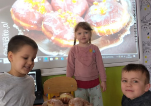 dzieci z pączkami ułożonymi na tacy