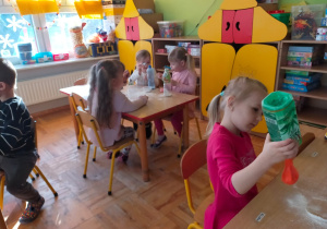 dzieici wsypują mąkę do balonów
