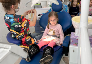 dziewczynka siedzi na fotelu stomatologicznym
