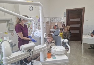 chłopiec siada na fotelu stomatologicznym