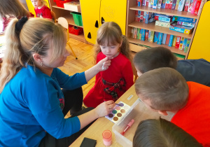 mama maluje dziewczynkom powieki