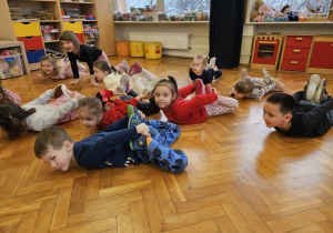 przedszkolaki wykonują ćwiczenie - kołyska