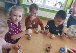 dzieci ozdabiają swoją babeczkę