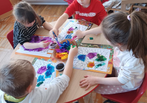 dzieci malują kwiaty kolorową bibułą maczaną w wodzie