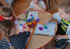 dzieci malują kwiaty kolorową bibułą maczaną w wodzie