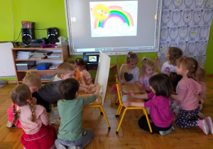 dzieci malują tęczę farbami