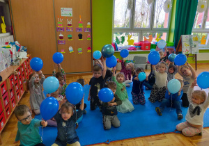 przedszkolaki w niebieskich ubraniach z niebieskimi balonami