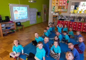 dzieci w niebieskich koszulkach oglądają film edukacyjny
