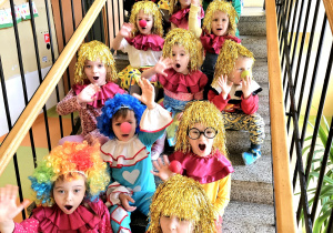 przedszkolaki klauni pozują do zdjęcia na schodach