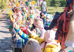 przedszkolaki ustawione w korowodzie przed budynkiem przedszkola z rekwizytami
