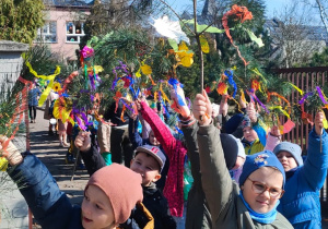 dzieci wychodzą z terenu przedszkola na ulice miasta w wiosennym korowodzie