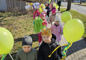 przedszkolaki w wiosennymi korowodzie na ulicach miasta idą z balonami